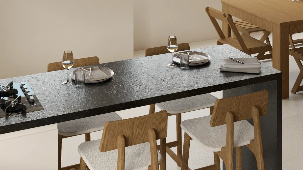 Detalhe da ilha de granito preto com cooktop, pratos postos e banquetas de madeira